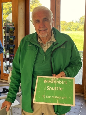 Westonbirt volunteer holding a shuttle bus sign